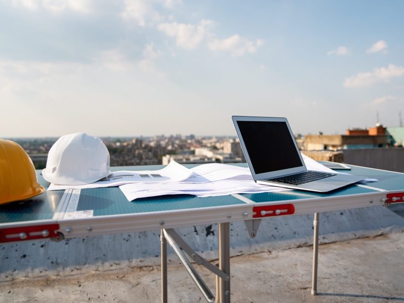 Concept of architects, engineer equipments on the desk with a blueprint in construction site.