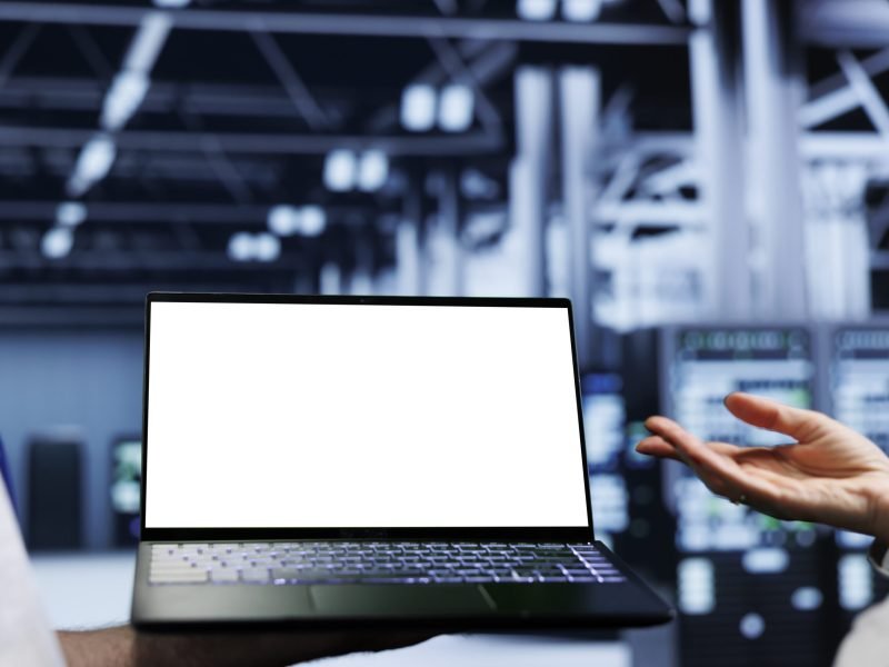 Close up shot of mock up laptop used by precise worker in data center supercomputer room delivering massive computing power, capable of processing and storing vast amounts of datasets